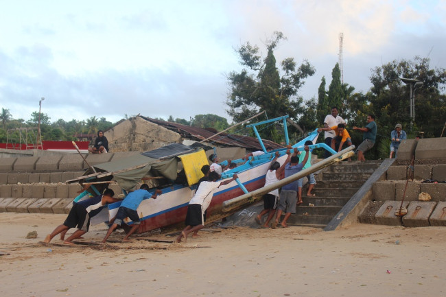 Nelayan menaikan perahu NBS